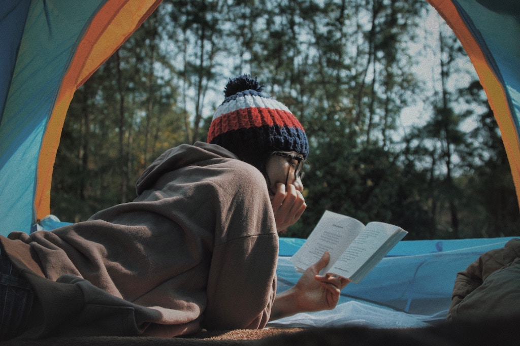 Titelbild für das vierte Lesesofa: Lesende Person in einem Zelt. Foto: Le Tan, unsplash